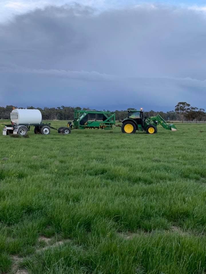 Tractor and tanker on a rural paddock under an overcast sky